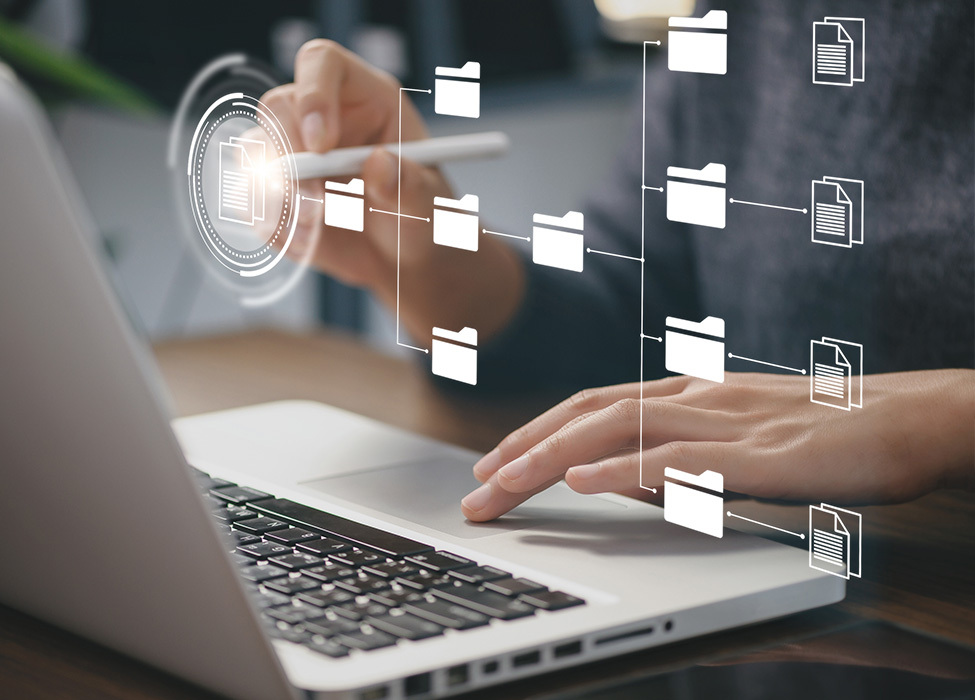 Digital Filing Cabinet: Close up of person typing on laptop with icons floating in front of laptop