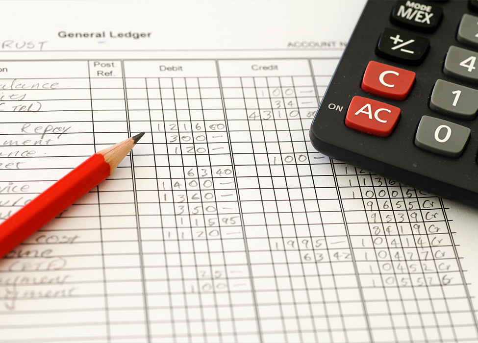 Financial Management Software | Close up of a general ledger with a pencil and calculator 